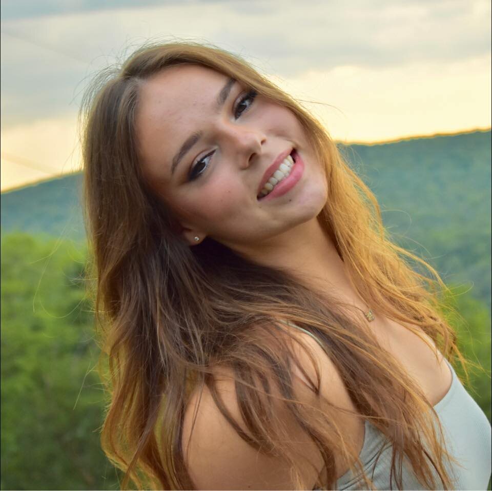 Elise Gregory, REALTOR®, outdoors with the ridge behind her