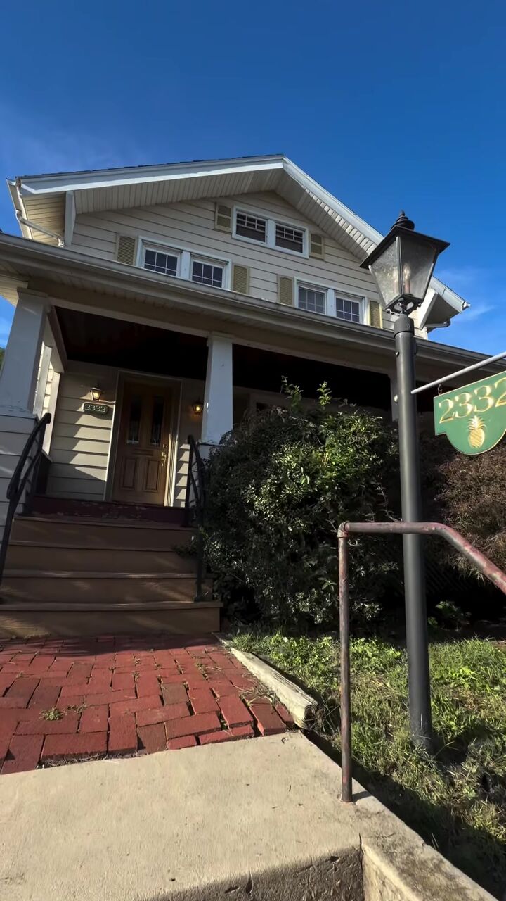 Craftsman-style home with a covered front porch and brick walk