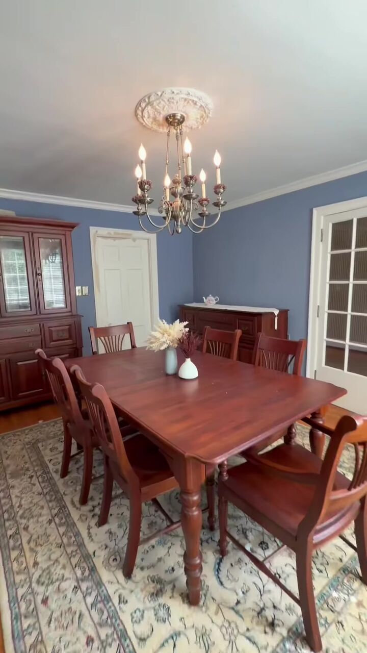 Dining room with a chandelier, china hutch and blue walls